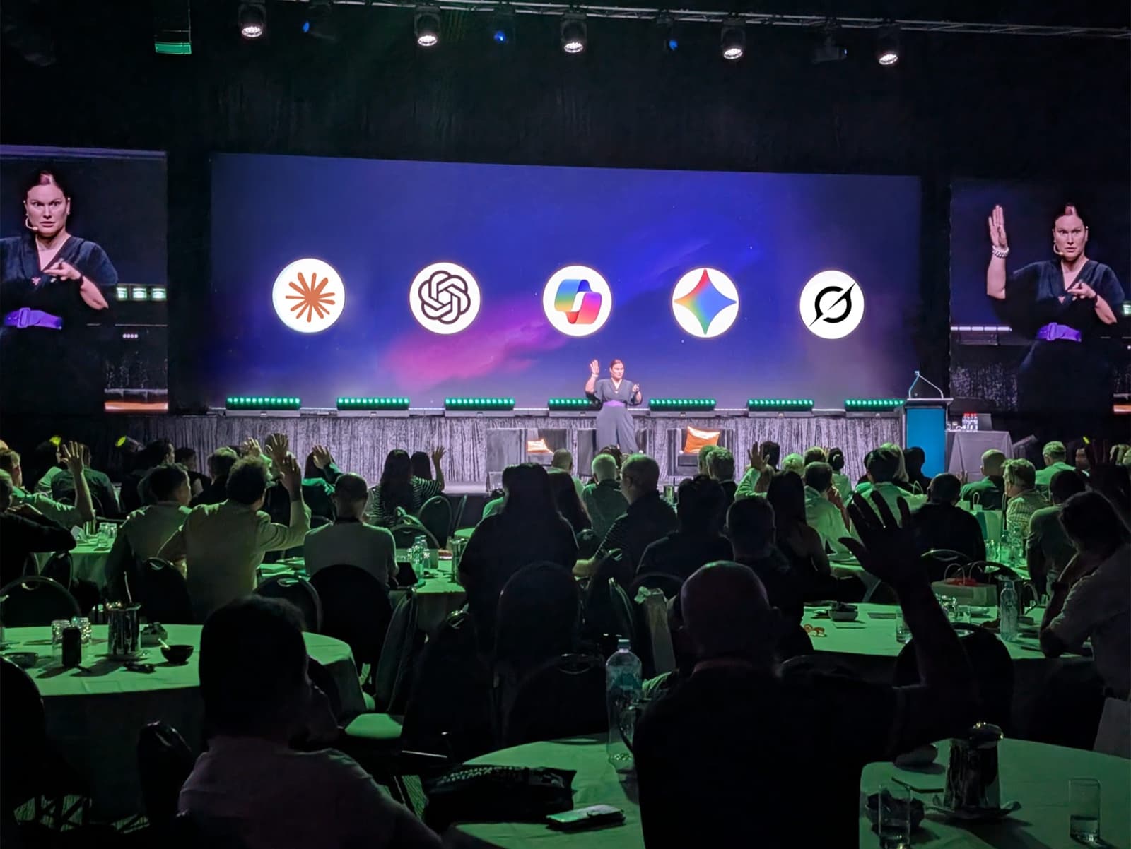 Jodee Bibaeff presenting an AI Mastery session on an arena stage