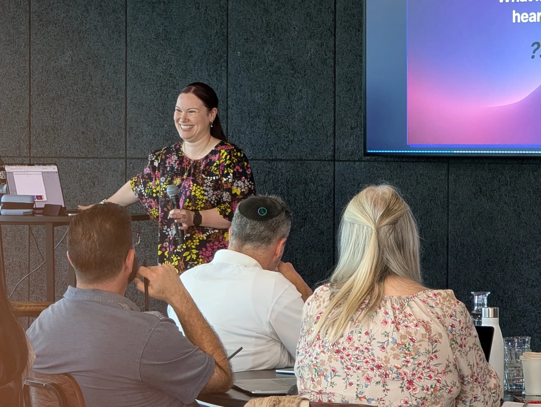 Jodee Bibaeff sharing a laugh with the room while presenting an AI Mastery workshop